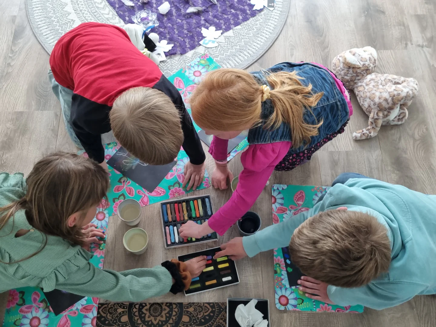 Kinderen tekenen samen met pastelkrijt tijdens de kinderyogales in Spanbroek, gemeente Opmeer